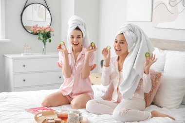 Beautiful young women taking care of their skin at home clipart
