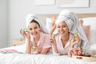 Güzel genç kadınlar evde ciltleriyle ilgileniyorlar.