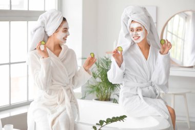 Güzel genç kadınlar banyoda ciltleriyle ilgileniyorlar.