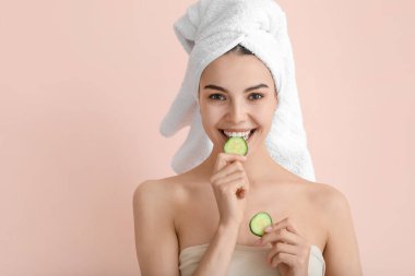 Arka planda salatalık dilimleri olan güzel genç bir kadın.