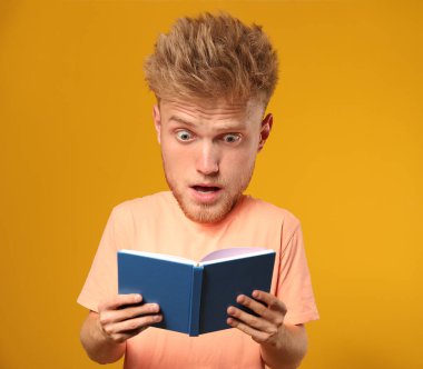 Gergin erkek öğrenci, koca kafalı, renkli arka planda.