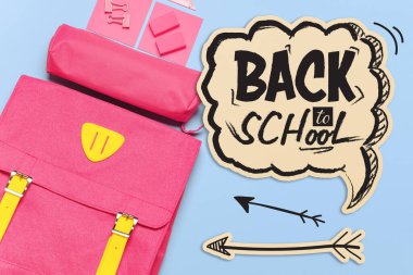 Kırtasiye malzemesi ve cümle içeren sırt çantası renk arkaplan üzerinde okula geri dönsün