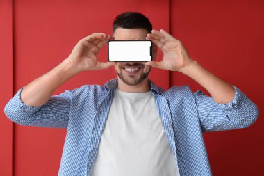 Renkli arka planda cep telefonu olan yakışıklı bir adam