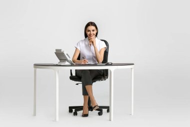 Masadaki güzel genç sekreter beyaz arka planda.