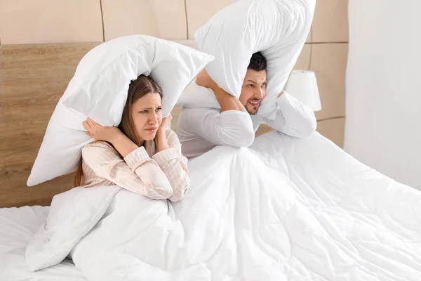 Young couple cannot sleep because of rowdy neighbours