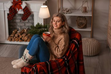 Güzel genç bayan evde sıcak çikolata içiyor.