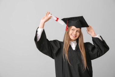 Açık arka planda diploması olan mezun bir bayan öğrenci.