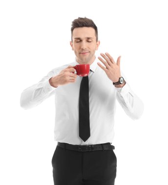 Yakışıklı iş adamı beyaz arka planda kahve içiyor.