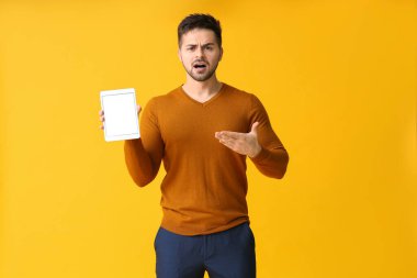 Renkli tablet bilgisayarlı hoşnutsuz genç adam