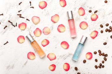 Hafif arka planda malzemeleri olan rulo parfüm şişeleri.