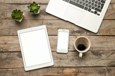 Tablet bilgisayar, cep telefonu, dizüstü bilgisayar ve bir fincan kahve.