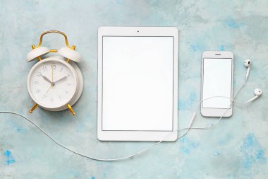 Tablet bilgisayar, cep telefonu, çalar saat ve kulaklık.