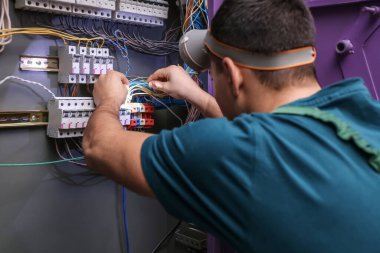 El feneri dağıtım panosunu tamir eden erkek elektrikçi.