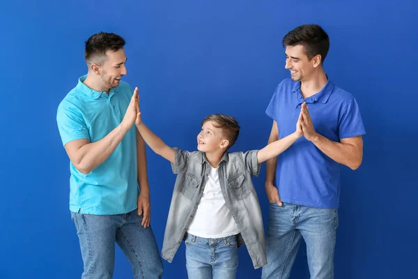 Glückliches Homosexuelles Paar Mit Adoptivkind Auf Farbigem Hintergrund — Stockfoto