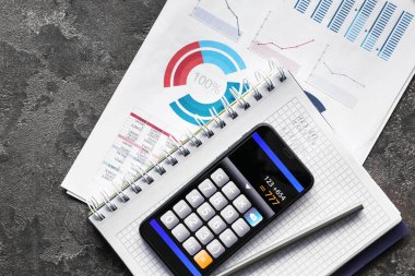 Telefon ekranında, kırtasiyede ve koyu arkaplanda hesaplayıcı mobil uygulama