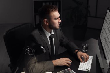 Genç işadamı gece geç saatlerde ofiste çalışıyor.