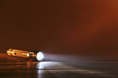 Parlayan modern el feneri ahşap masada.