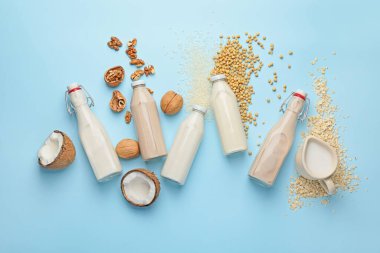 Renkli arka planda farklı süt şişeleri