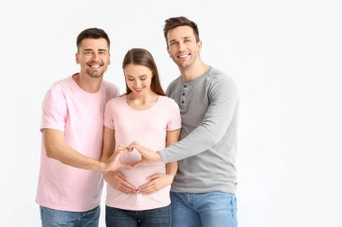 Beyaz arka planda hamile bir kadınla eşcinsel çift.