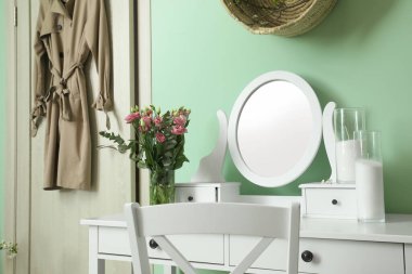 Odanın içinde şık aynalar ve bahar çiçekleri.