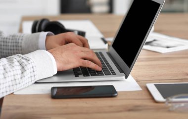 Bilgisayarlı genç adam evde çalışıyor.