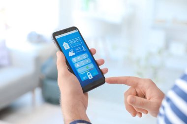 Akıllı ev otomasyonu uygulaması kullanan adam