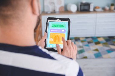 Akıllı ev otomasyonu uygulaması kullanan adam