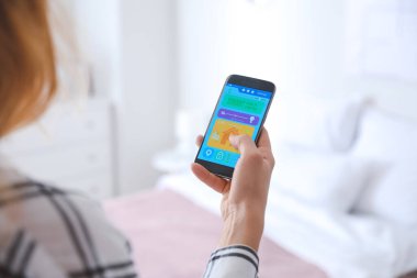 Akıllı ev otomasyonu uygulaması kullanan kadın