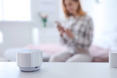 Yatak odasındaki masada akıllı ev asistanı aygıtı