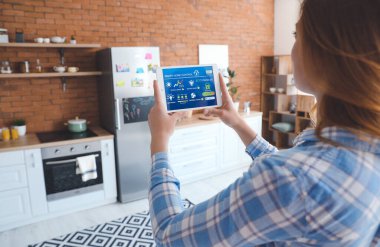 Akıllı ev otomasyonu uygulaması kullanan kadın