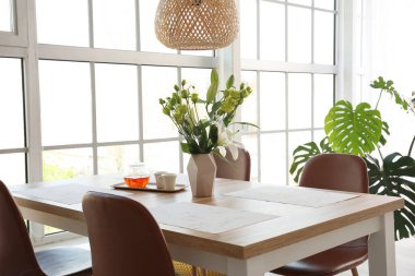 Yemek odasındaki masada çiçek dekoru.