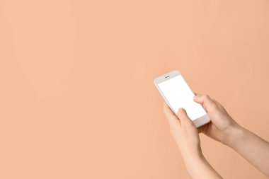 Renkli arka planda cep telefonu olan kadın elleri