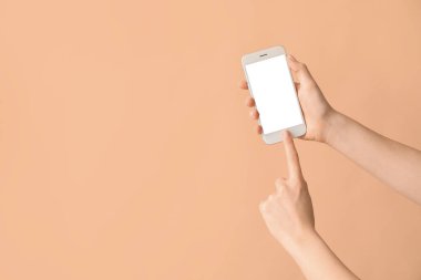 Renkli arka planda cep telefonu olan kadın elleri