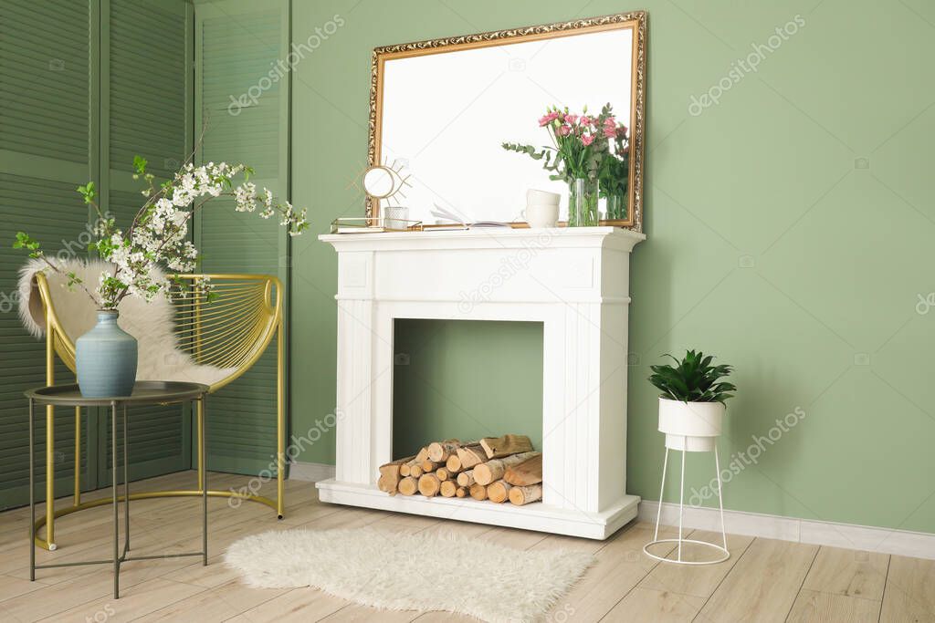 Interior of living room with fireplace, stylish mirror and flowers
