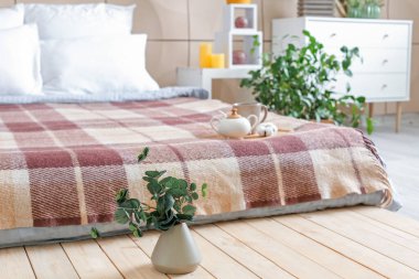 Yatak odasının içinde yeşil bitkiler var.