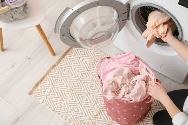 Evde çamaşır yıkayan genç bir kadın.