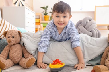 Küçük çocuk evde oynuyor.