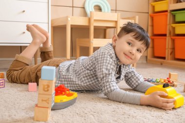 Küçük çocuk evde oynuyor.