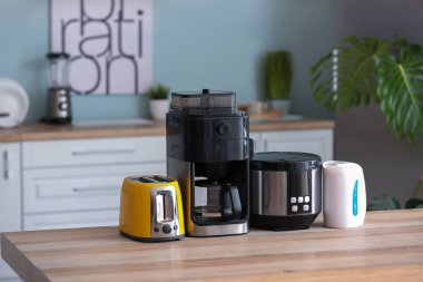 Mutfaktaki masada farklı ev aletleri var.