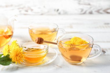 Sağlıklı karahindiba çayı ve bal beyaz ahşap arka planda