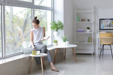 Evde çalışan genç bayan tasarımcı.