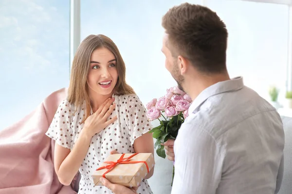 男人在家里送花束和礼物给女朋友 — 图库照片