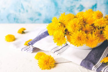 Masada güzel karahindibalar olan bir kase.