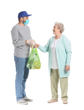 Yemek dağıtım şirketinin kuryesi beyaz arka plandaki yaşlı kadına ürünler veriyor. Salgın kavramı