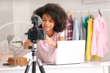 Afro-Amerikalı genç blogcu kamerayı evdeki video kaydı için ayarlıyor