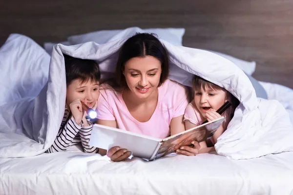 Vrouw Haar Kleine Kinderen Lezen Boek Onder Deken Nachts — Stockfoto