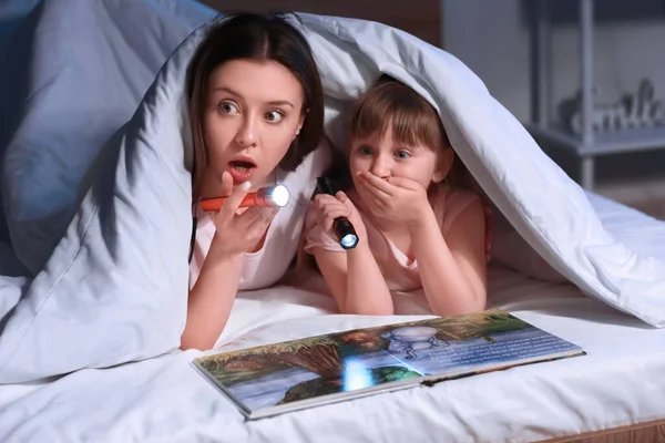 Женщина Маленькая Дочь Читают Книги Одеялом Ночью — стоковое фото