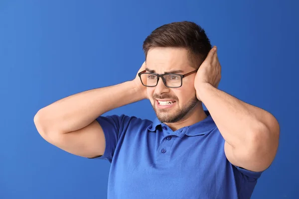 Young Man Suffering Loud Noise Color Background — Stock Photo, Image