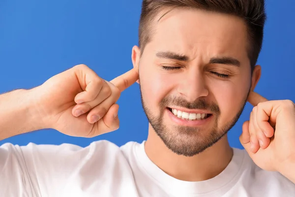 Young Man Suffering Loud Noise Color Background — Stock Photo, Image
