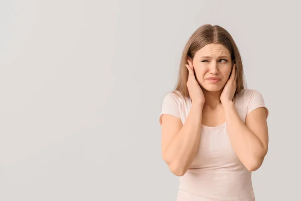 Young Woman Suffering Loud Noise Light Background — Stock Photo, Image